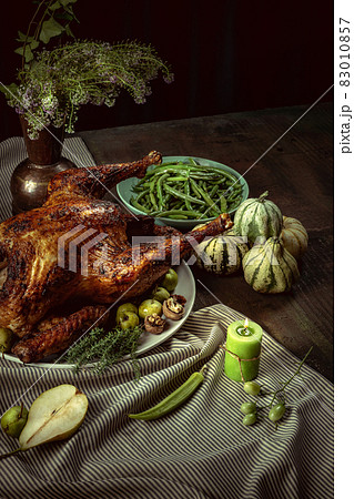 Top view of holiday decorated table with roasted turkey and season traditional vegetables. Thanksgiving day, national traditions Top view of holiday decorated table with roasted turkey and season traditional vegetables. Thanksgiving day, national traditions 83010857