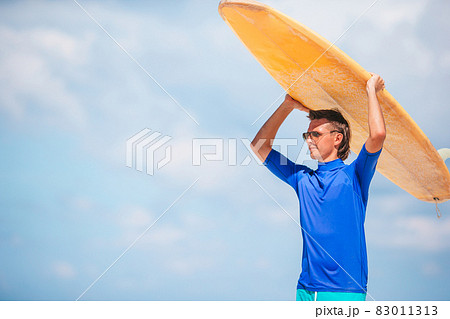 Young surf man at white beach with yellow surfboard Young surf man at white beach with yellow surfboard 83011313
