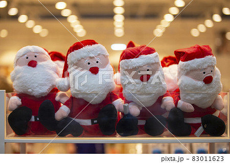 Many Santa Claus toys in a store window. Christmas sale of souvenirs. 83011623