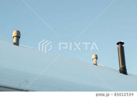 Three chimneys on the snow-covered roof 83012534