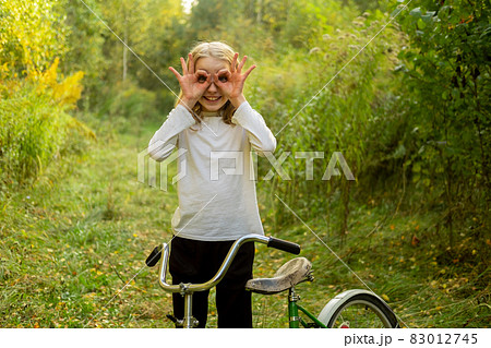Beautiful Caucasian teenage girl on a bicycle in the woods in nature Beautiful Caucasian teenage girl on a bicycle in the woods in nature 83012745