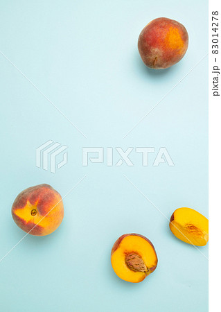 Fresh juicy peaches with leaves on a blue background. Top view fresh organic fruit food with copy space. Frame made of fresh peashes. Fresh juicy peaches with leaves on a blue background. Top view fresh organic fruit food with copy space. Frame made of fresh peashes. 83014278