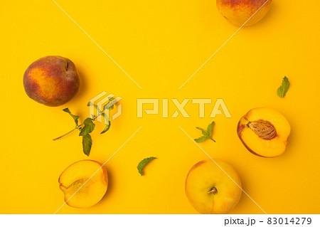 Ripe juicy peaches on yellow background. Flat lay, top view, copy space. Frame made of fresh peashes. 83014279