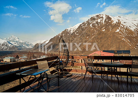 Terrace of a house in a village in the mountains. Breathtaking views of the snow-capped mountains Terrace of a house in a village in the mountains. Breathtaking views of the snow-capped mountains 83014705