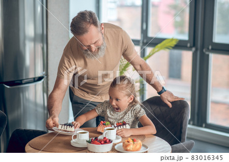 Dad and his daughter having breakfast together at home Dad and his daughter having breakfast together at home 83016345