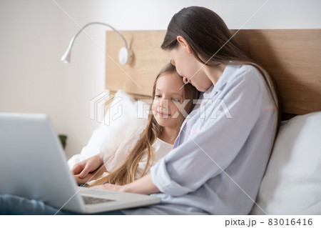 Mom and daughter spending time together and looking peaceful 83016416