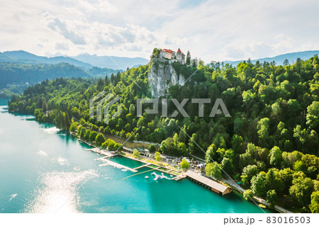 Aerial view of mediaeval Bled castle on the cliff of the mountain under lake Bled with turquoise blue water in Slovenia 83016503