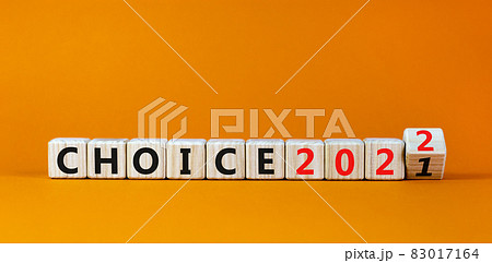 Planning 2022 choice new year symbol. Turned a wooden cube and changed words 'choice 2021' to 'choice 2022'. Beautiful orange background, copy space. Business, 2022 choice new year concept. 83017164