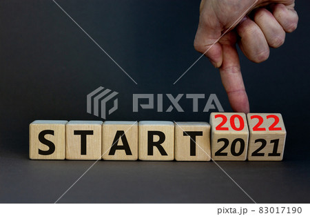 2022 start new year symbol. Businessman turns wooden cubes and changes words 'Start 2021' to 'Start 2022'. Beautiful grey background, copy space. Business, 2022 start new year concept. 83017190