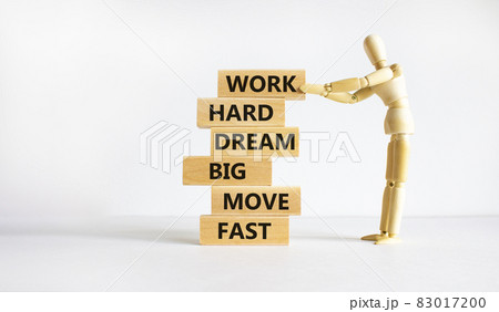 Work hard dream big symbol. Words Work hard dream big move fast on wooden blocks on a beautiful white background. Businessman model. Business, motivational and work hard dream big move fast concept. 83017200