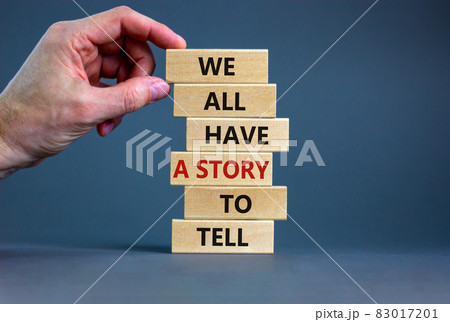 We all have a story to tell symbol. Wooden blocks with words 'We all have a story to tell'. Businessman hand. Beautiful grey background. Business, popular quotation concept. Copy space. 83017201