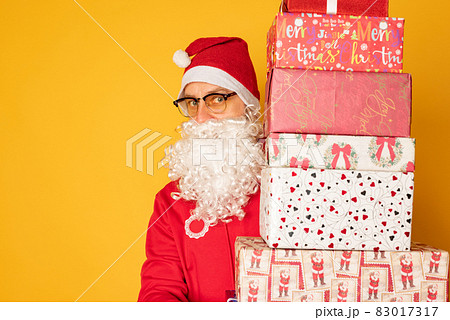 Santa Claus brought gifts for Christmas. Modern young santa on yellow background Santa Claus brought gifts for Christmas. Modern young santa on yellow background 83017317