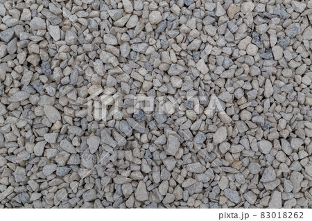Dry white limestone ballast flat full frame background. Small gray dusty broken macadam stones texture. 83018262