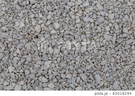 Dry white limestone ballast flat full frame background. Small gray dusty broken macadam stones texture. Dry white limestone ballast flat full frame background. Small gray dusty broken macadam stones texture. 83018294
