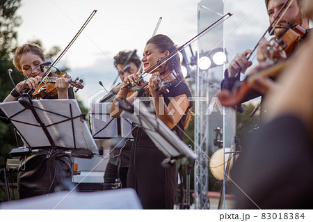 Violin players giving concert on the street 83018384
