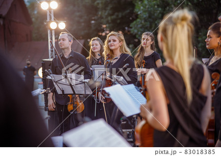 Violin players having orchestra rehearsal on the street 83018385