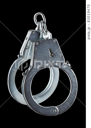 real zinc plated steel police handcuffs closed, isolated on black background 83019470