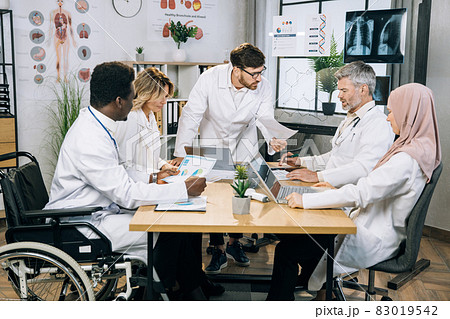 Multicultural group of doctors working on gadgets at office 83019542