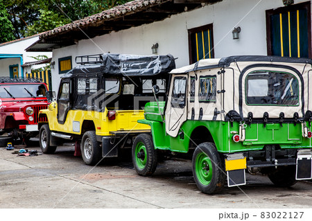 Traditional off-road vehicles parked at a beautiful street in the small town of Salento located at the region of Quindio in Colombia 83022127