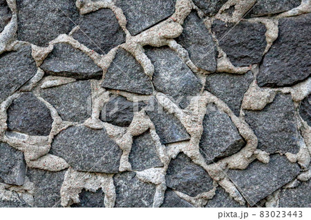 Stones in gray cement textured stucco background 83023443