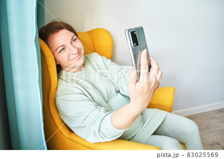 Young woman doing self portrait indoors. Home vacation portrait. Blogger selfie Young woman doing self portrait indoors. Home vacation portrait. Blogger selfie 83025569