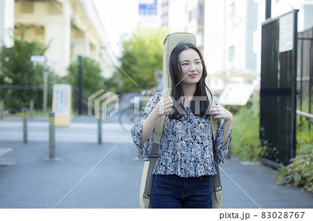 ギターケースを持って歩く女性 ギターケースを持って歩く女性 83028767