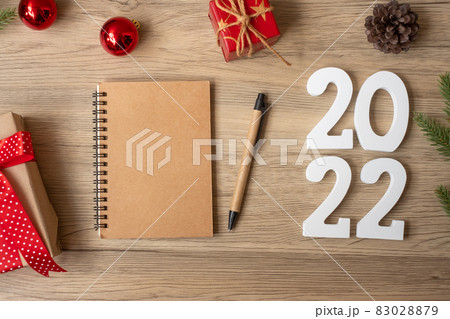 2022 New Year with notebook, Christmas gift and pen on wood table. Xmas, Happy New Year, Goals, Resolution, To do list, start, Strategy and Plan concept 83028879
