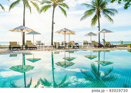 Beautiful umbrella and chair around swimming pool in hotel and resort 83029730