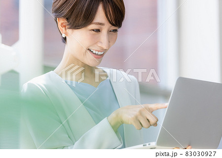 立ってパソコン作業をするビジネスウーマン 立ってパソコン作業をするビジネスウーマン 83030927