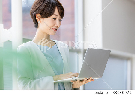 立ってパソコン作業をするビジネスウーマン 83030929