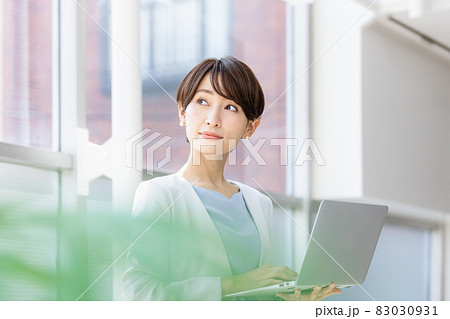 立ってパソコン作業をするビジネスウーマン 83030931