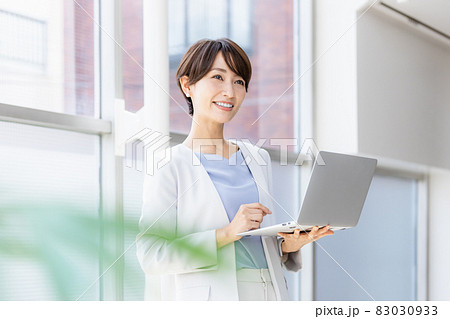 立ってパソコン作業をするビジネスウーマン 83030933
