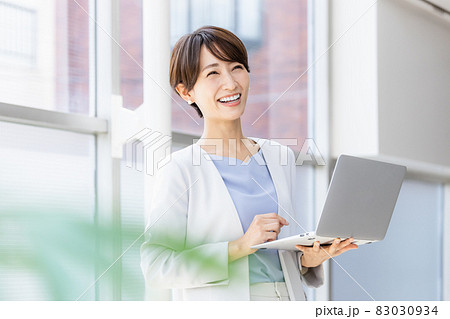 立ってパソコン作業をするビジネスウーマン 83030934
