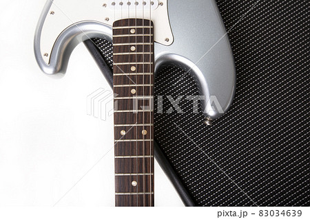 Silver electric guitar on guitar amplifier isolated on white background. Silver electric guitar on guitar amplifier isolated on white background. 83034639