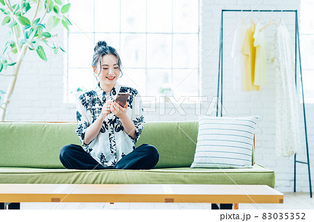 リビングでスマホを見る若い女性 リビングでスマホを見る若い女性 83035352