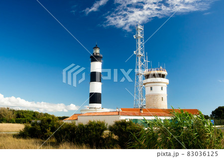 Lighthouse with blue sky and summer clouds and terracotta roof top in chassiron, Oleron Island, France 83036125