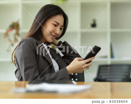 Female employee relaxed on her smartphone, scrolling through social media 83036604
