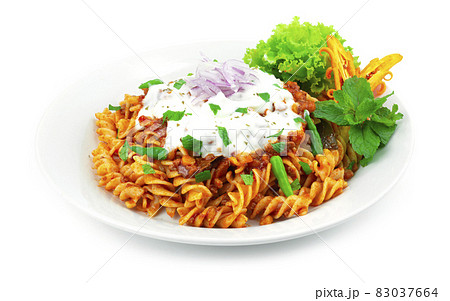 Pasta Bolognese Lentil Curry Sauce ontop Yogurt Sauce and leaf mint 83037664