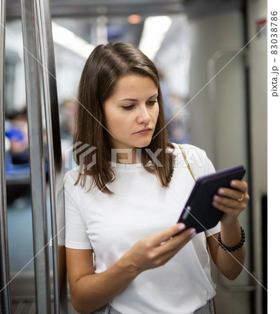 Woman using tablet in subway car Woman using tablet in subway car 83038786
