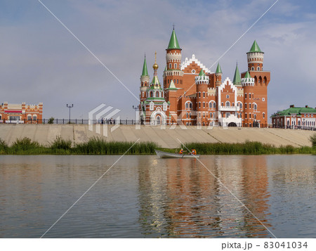 A pond with a pleasure boat and an embankment with buildings in Yoshkar-Ola, Russia 83041034