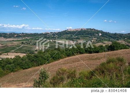 Montepulciano, Tuscany, Italy. August 2020. Amazing landscape of the Tuscan countryside with the historic village of Montepulciano on the top of the hill. Beautiful summer day. Montepulciano, Tuscany, Italy. August 2020. Amazing landscape of the Tuscan countryside with the historic village of Montepulciano on the top of the hill. Beautiful summer day. 83041408