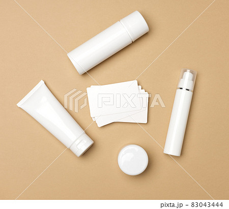 jar, bottle and empty white plastic tubes for cosmetics on a beige background. Packaging for cream, gel, serum, advertising and product promotion, mock up, top view 83043444