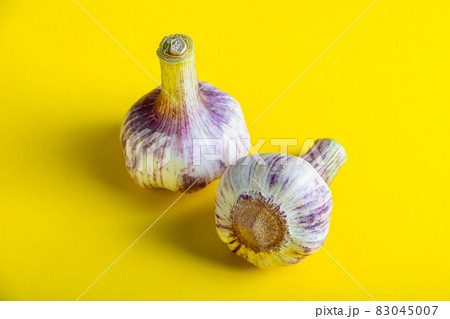 Fresh aromatic garlic on a yellow background close-up. Fresh aromatic garlic on a yellow background close-up. 83045007