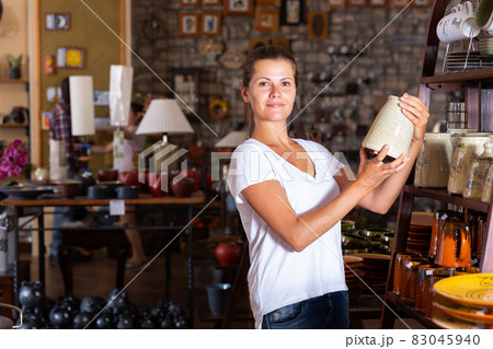 Female choosing handmade earthenware 83045940