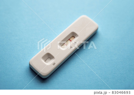 Coronavirus antigen test with a positiv result on a blue background. Copy space. Coronavirus antigen test with a positiv result on a blue background. Copy space. 83046693