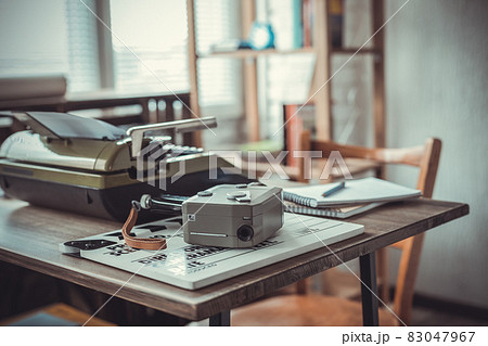 Vintage old film camera and typewriter at wooden desk table 83047967