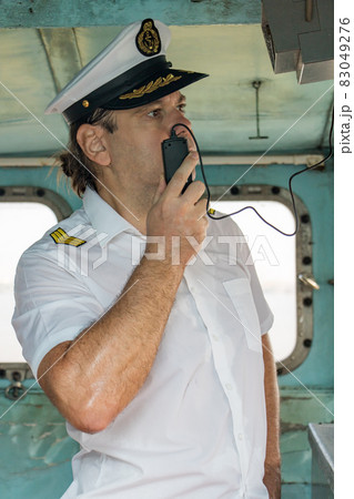 Navigation officer manage ship with transmitter. Captain standing in the wheelhouse. Navigation officer manage ship with transmitter. Captain standing in the wheelhouse. 83049276