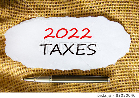 2022 taxes new year symbol. Words '2022 taxes', on white paper. Black metallic pen. Beautiful canvas background. Business and 2022 taxes new year concept. Copy space. 2022 taxes new year symbol. Words '2022 taxes', on white paper. Black metallic pen. Beautiful canvas background. Business and 2022 taxes new year concept. Copy space. 83050046
