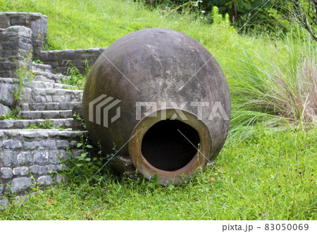 Big old clay jug. Old ancient clay vase outdoors. Still life of ceramic pots. Selective focus. Old clay jugs in the brick and stone place. A traditional Georgian clay wine jug on a stone background. 83050069