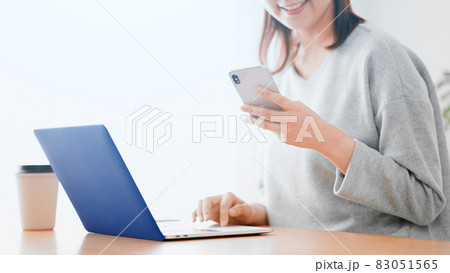 ノートパソコンとスマートフォンを使う女性 83051565